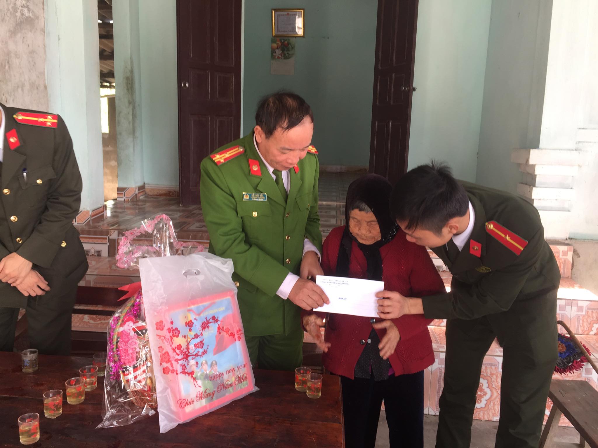 Đồng chí Thượng tá Hồ Phúc Đóa, Phó trưởng CA huyện tặng quà cho mẹ Vũ Thị Ngân