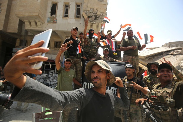 Binh lính Iraq ăn mừng sự kiện IS bị đánh bại. Ảnh: EPA
