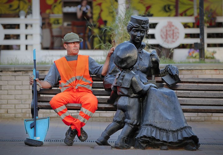 Một công nhân ngồi nghỉ trên ghế băng, ngay cạnh bức tượng ở Nizhny Novgorod của Nga, ngày 28/6.