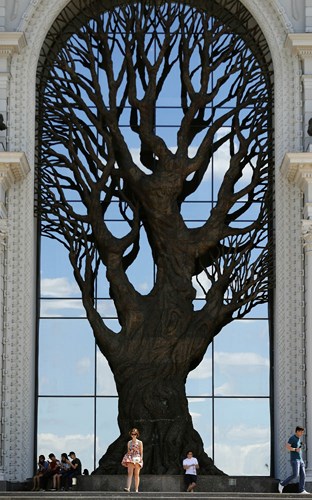 Khách du lịch chụp hình trước tạo hình một gốc cây bằng đồng cao 20m ở trung tâm thành phố Kazan của Nga trong dịp World Cup.