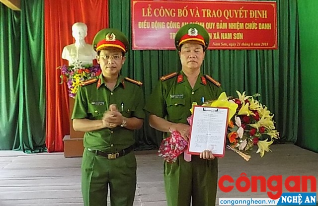 Thượng tá Đinh Anh Dũng, Trưởng Công an huyện Quỳ Hợp trao quyết định và tặng hoa chúc mừng Trung tá Quang Văn Thuyên, tân Trưởng Công an xã Nam Sơn