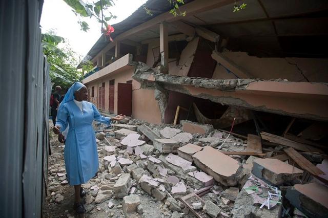 Xơ Maryse Alsaint đi bộ dọc một ngôi trường vừa bị trận động đất làm rung chuyển Haiti tàn phá. Ảnh: AP