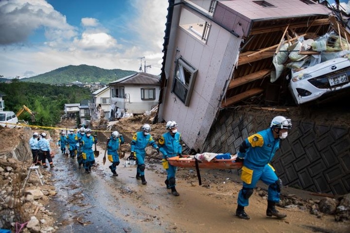 Cảnh sát đang dọn dẹp những mảnh vỡ nằm ngổn ngang trên đường phố sau khi trận lụt lịch sử nhấn chìm vùng Kumano, tỉnh Hiroshima trong biển nước ngày 9/7/2018. Các nhân viên cứu hộ ở Nhật Bản gặp rất nhiều khó khăn trong quá trình tiếp cận những người dân vùng lũ bị mắc kẹt. Ảnh: AFP