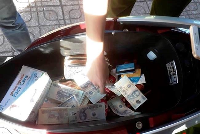 Nhiều tờ tiền ghép giữa 20.000 đồng và 500.000 đồng được phát hiện trong cốp xe của Nguyễn Thị Khẩn.
