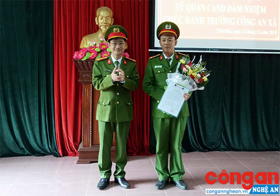 Trung tá Trần Ngọc Tuấn, Trưởng Công an TX Thái Hòa trao quyết định và tặng hoa chúc mừng tân Trưởng Công an xã Nghĩa Hòa