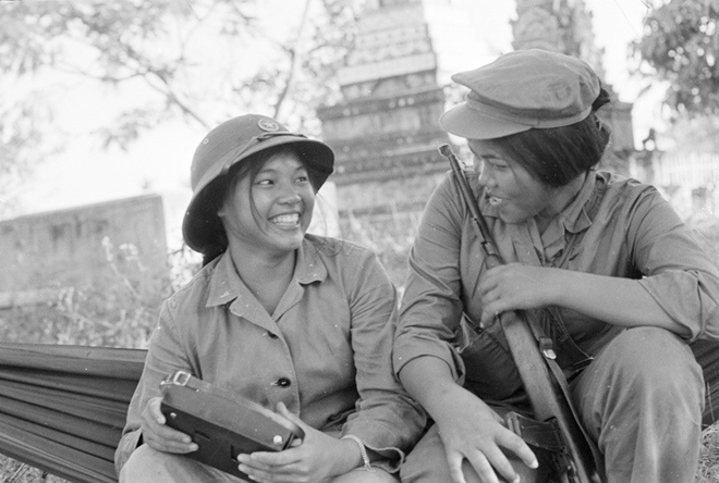 Trong ảnh là một nữ chiến sĩ quân tình nguyện Việt Nam và nữ chiến sĩ Campuchia vui vẻ trò chuyện trước khi chia tay khi quân tình nguyện Việt Nam rút về nước, hoàn thành nhiệm vụ quốc tế.