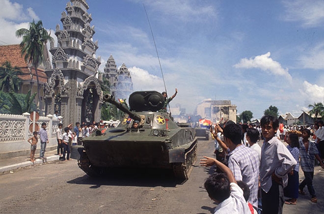 Đến tháng 6-1989, theo thỏa thuận giữa hai Đảng, hai Nhà nước, Việt Nam rút hết quân tình nguyện về nước hoàn thành nghĩa vụ quốc tế vẻ vang. Trong ảnh là người dân vẫy tay chào mừng những người lính tình nguyện Việt Nam trên một con đường ở thủ đô Phnom Penh.
