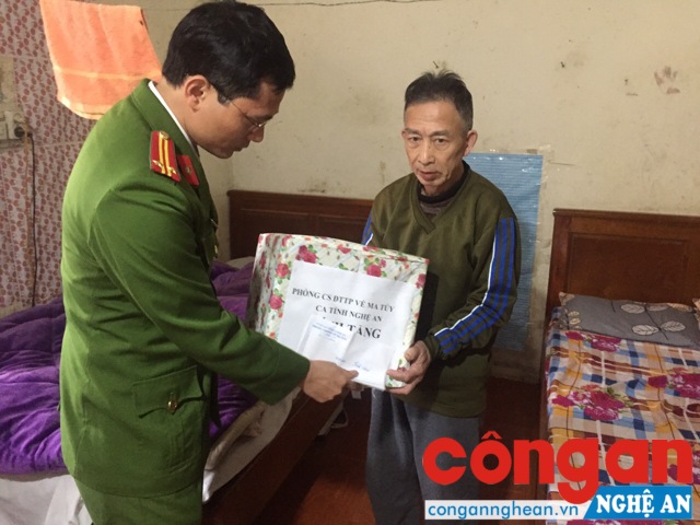 Đồng chí Trung tá Trần Đình Vinh - Phó trưởng phòng CSĐTTP về ma túy trực tiếp trao quà cho người dân