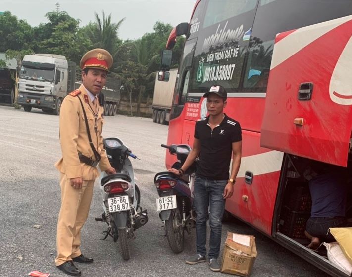 Đại uý Đàm Văn Linh cán bộ Trạm CSGT Diễn Châu kiểm tra xe khách và phát hiện 2 chiếc xe máy bị mất trộm.