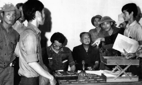 Nhà báo B.Gallasch (ngồi bên trái) giúp quân giải phóng ghi âm lời đầu hàng của Tổng thống Dương Văn Minh (ngồi bên phải) tại Đài Phát thanh Sài Gòn trưa ngày 30/4/1975. (Ảnh của Kỳ Sơn - hãng AP)