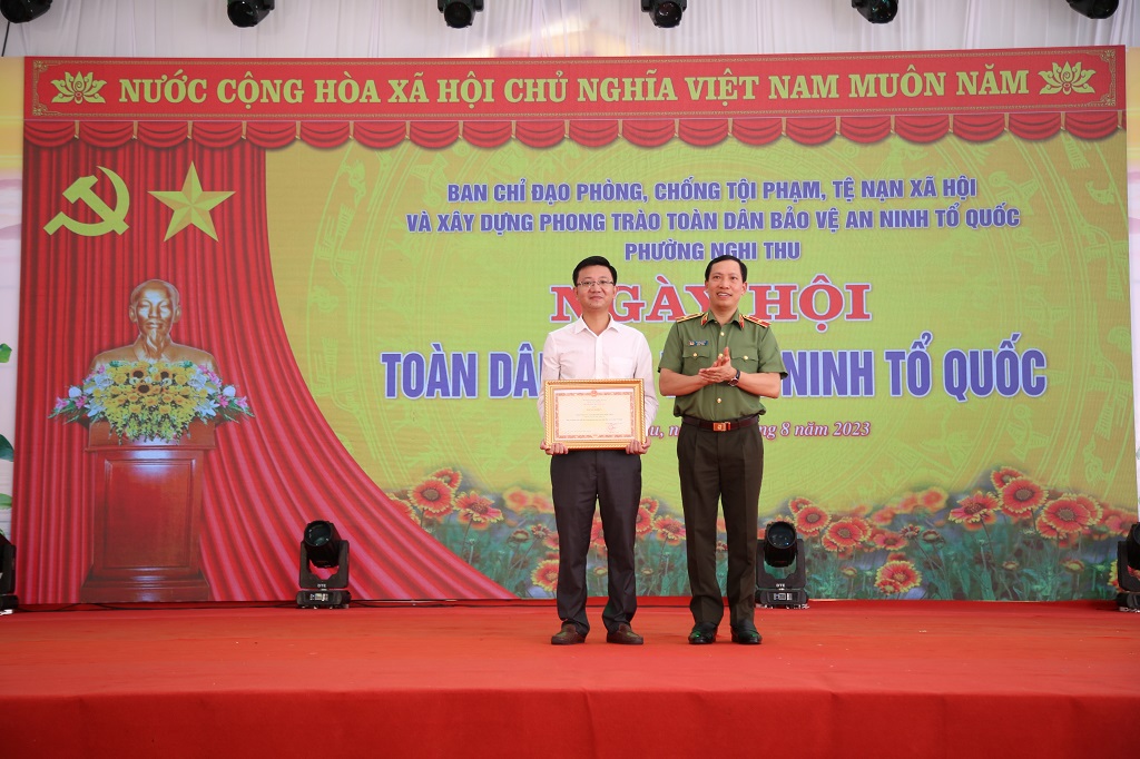 Đồng chí Thứ trưởng Lê Văn Tuyến trao Bằng khen của Bộ Công an tặng chính quyền phường Nghi Thủy đã có thành tích xuất sắc trong phong trào toàn dân bảo vệ ANTQ